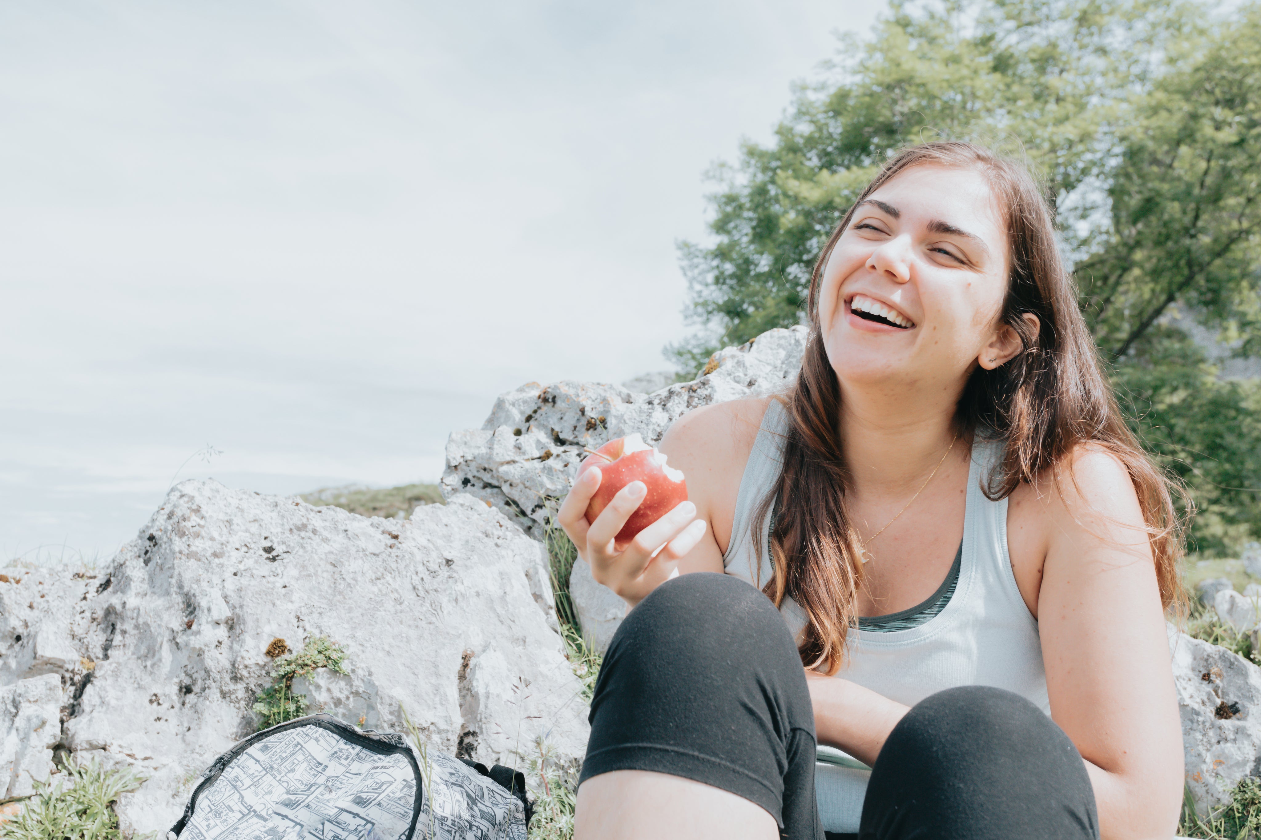 files/woman-eats-an-apple-outdoors-and-laughs.jpg